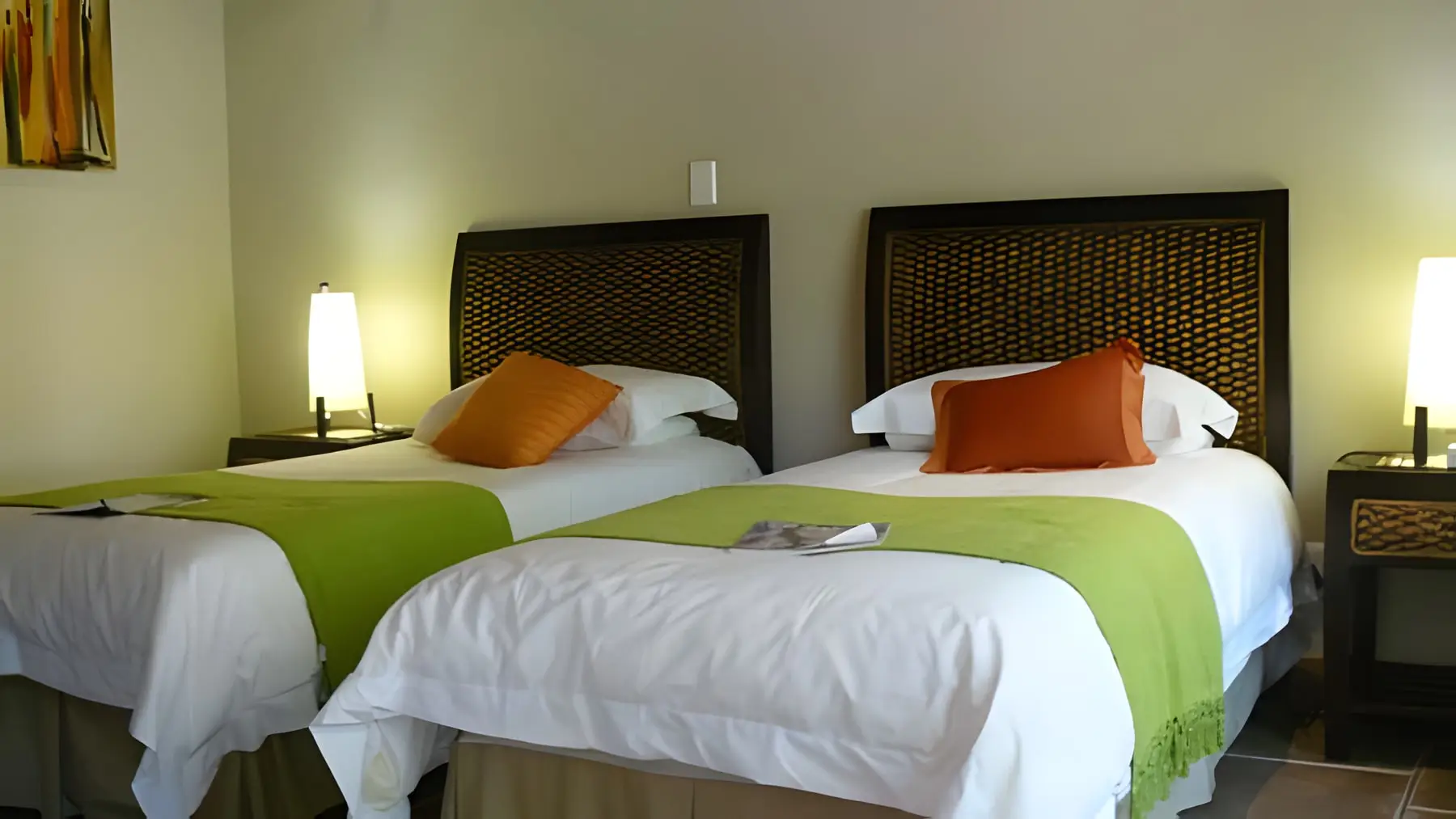 A twin room, the beds made up in green and orange