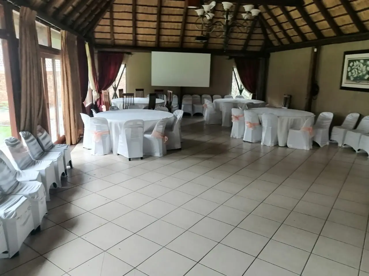 The lapa set for a function: round tables and dressed chairs under the thatch