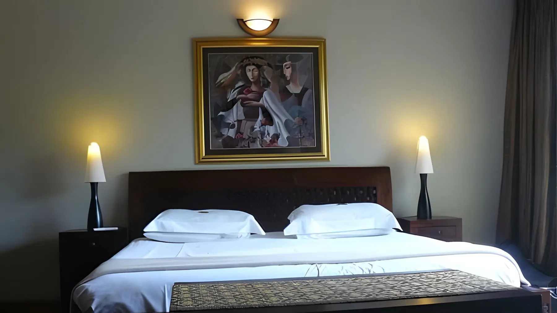 A double room with lamps either side of the bed